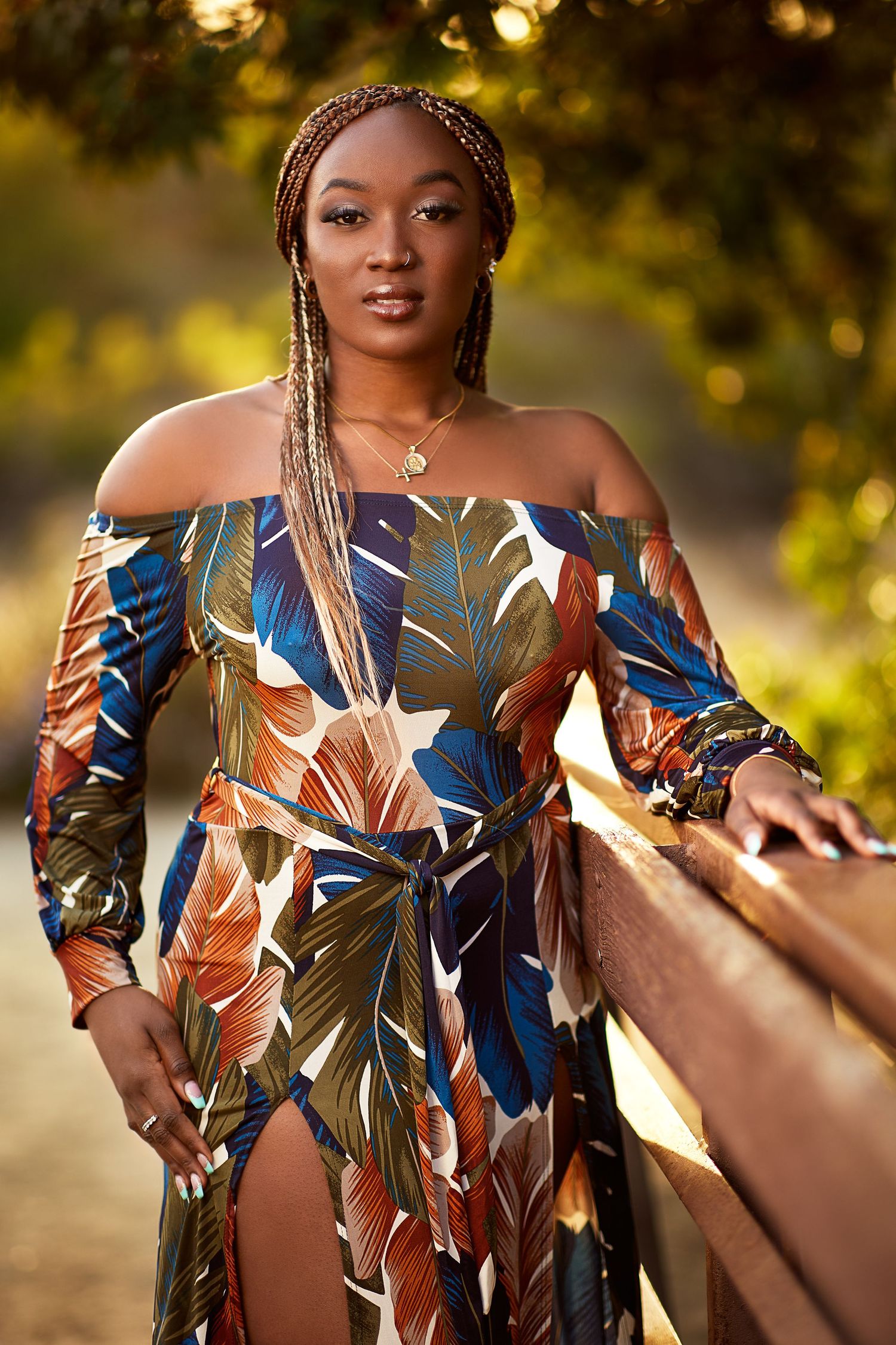 A floral off-shoulder maxi dress with blue and brown patterns photographed in golden evening light.