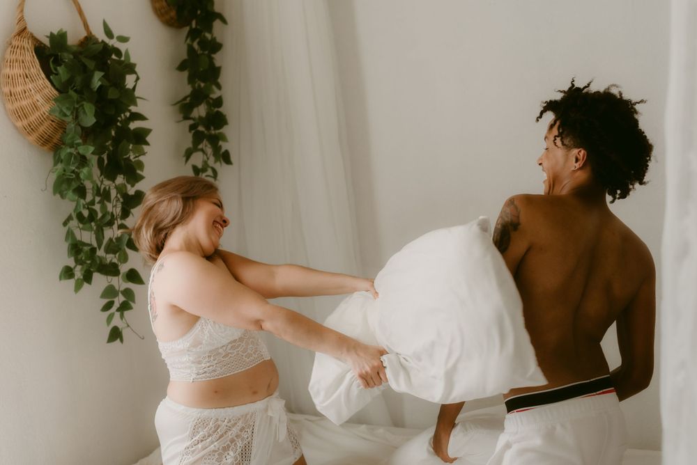 Playful moment captured during an intimate couples photoshoot with hanging plants.