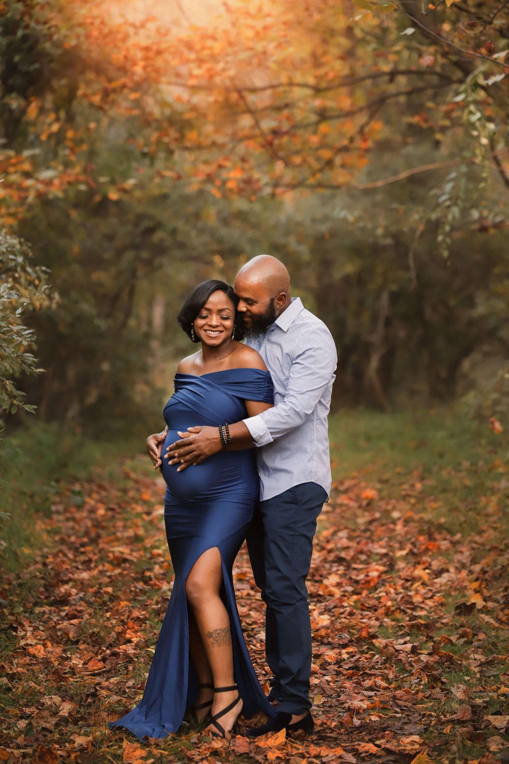 Fine art outdoor maternity portrait with family in Fall with long dress and leaves