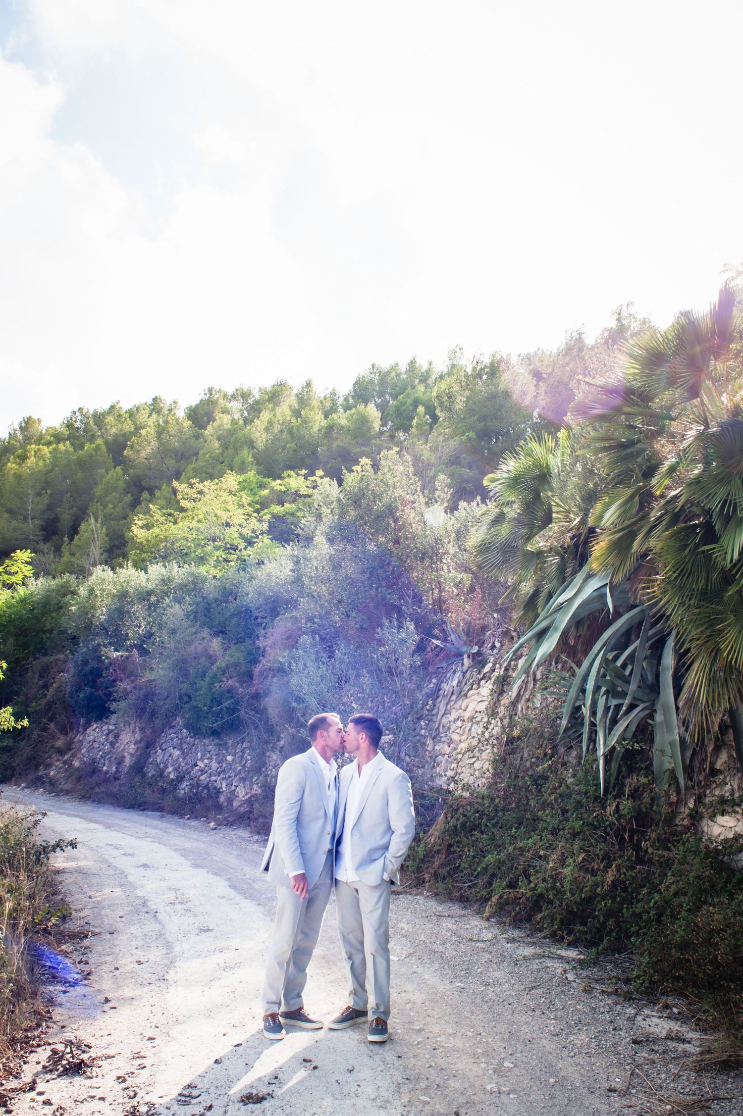 Groom and groom kiss on their wedding day photo shoot at Almiral de la Font, Sitges, Barcelona.