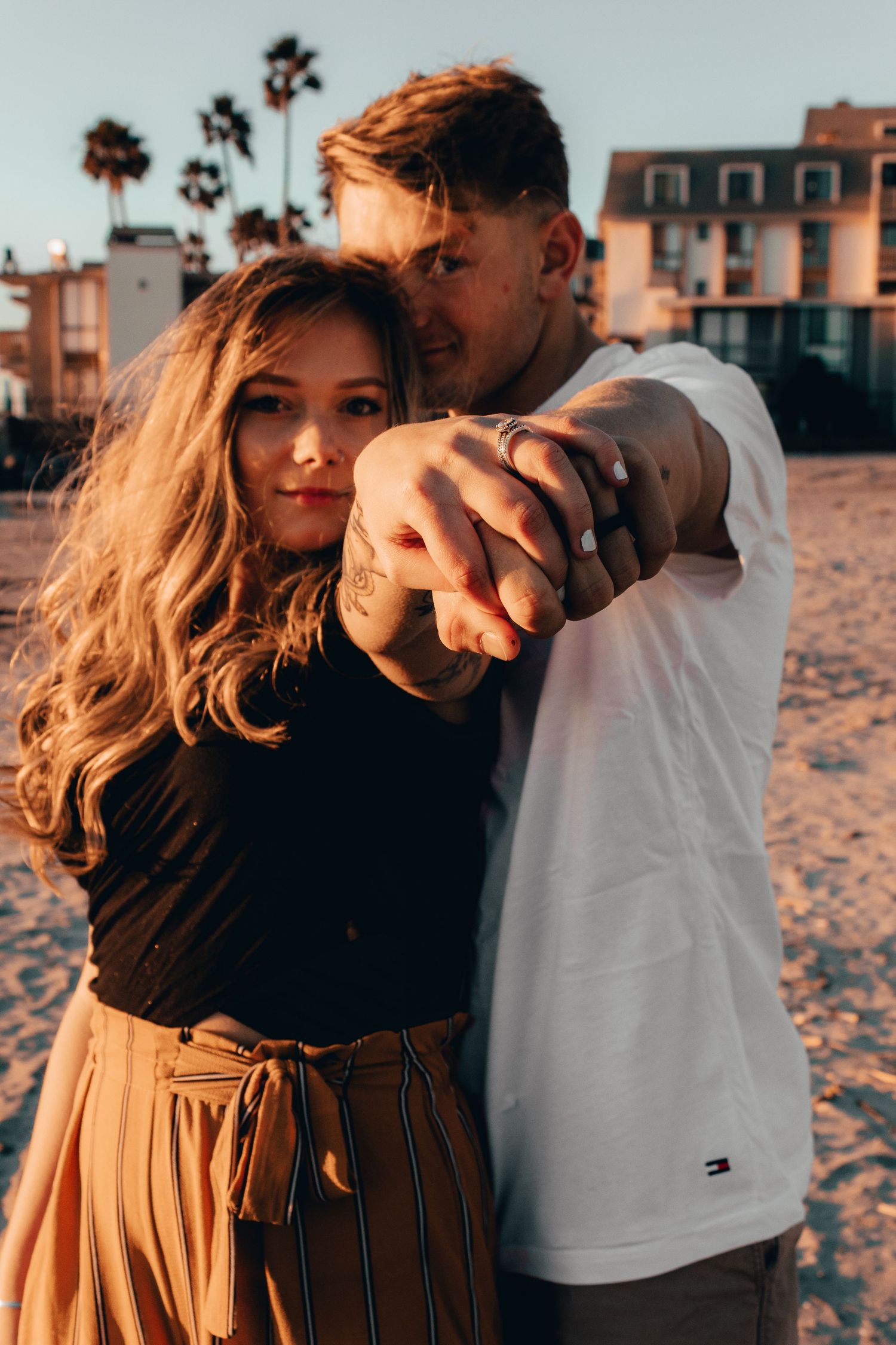 couple holding their hands out on the beach in oceanside, ca