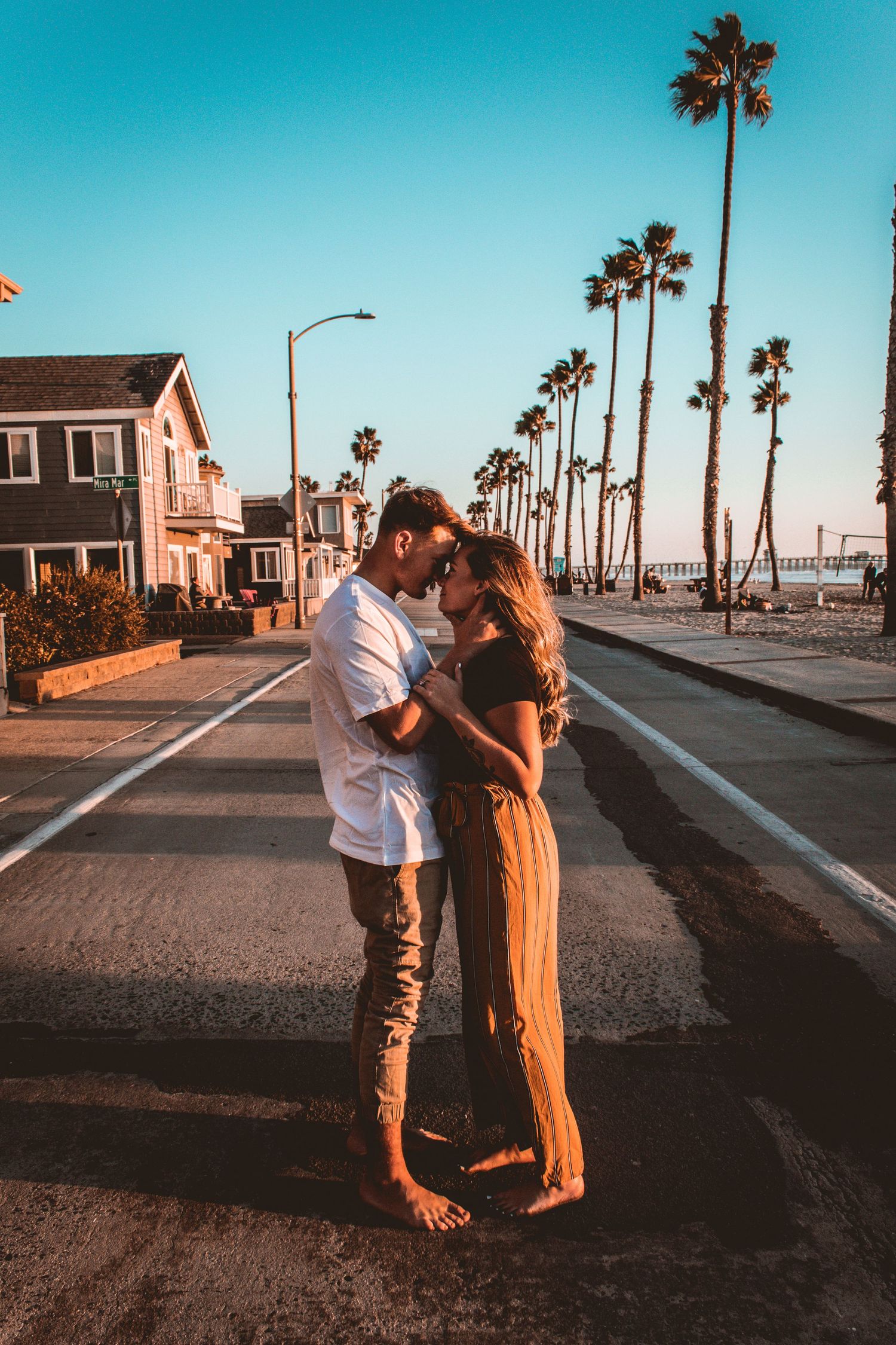 couple posing in the street by the beach in oceanside, ca