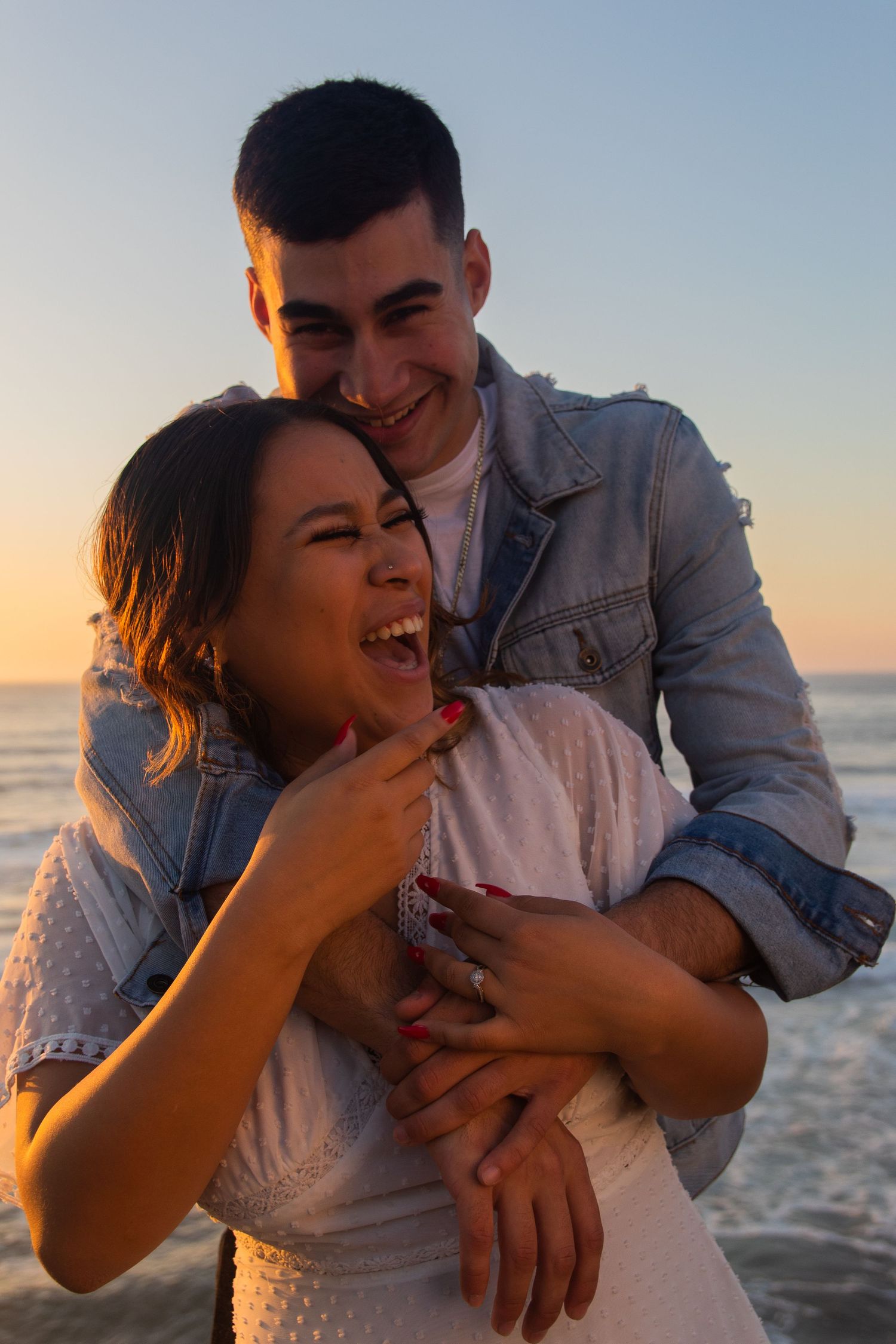 couple posing on the beach in the sunset at the sunset cliffs in san diego, ca