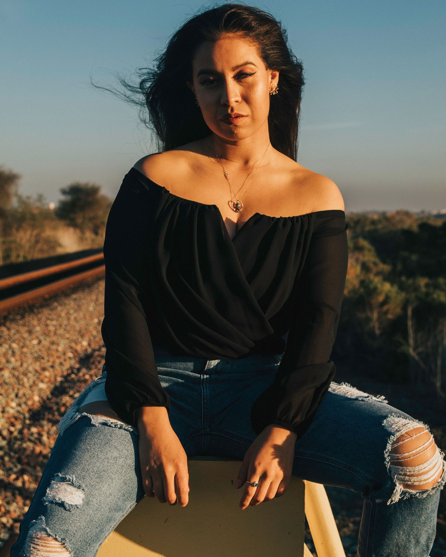 Woman posing in sunlight near train tracks in oceanside, ca