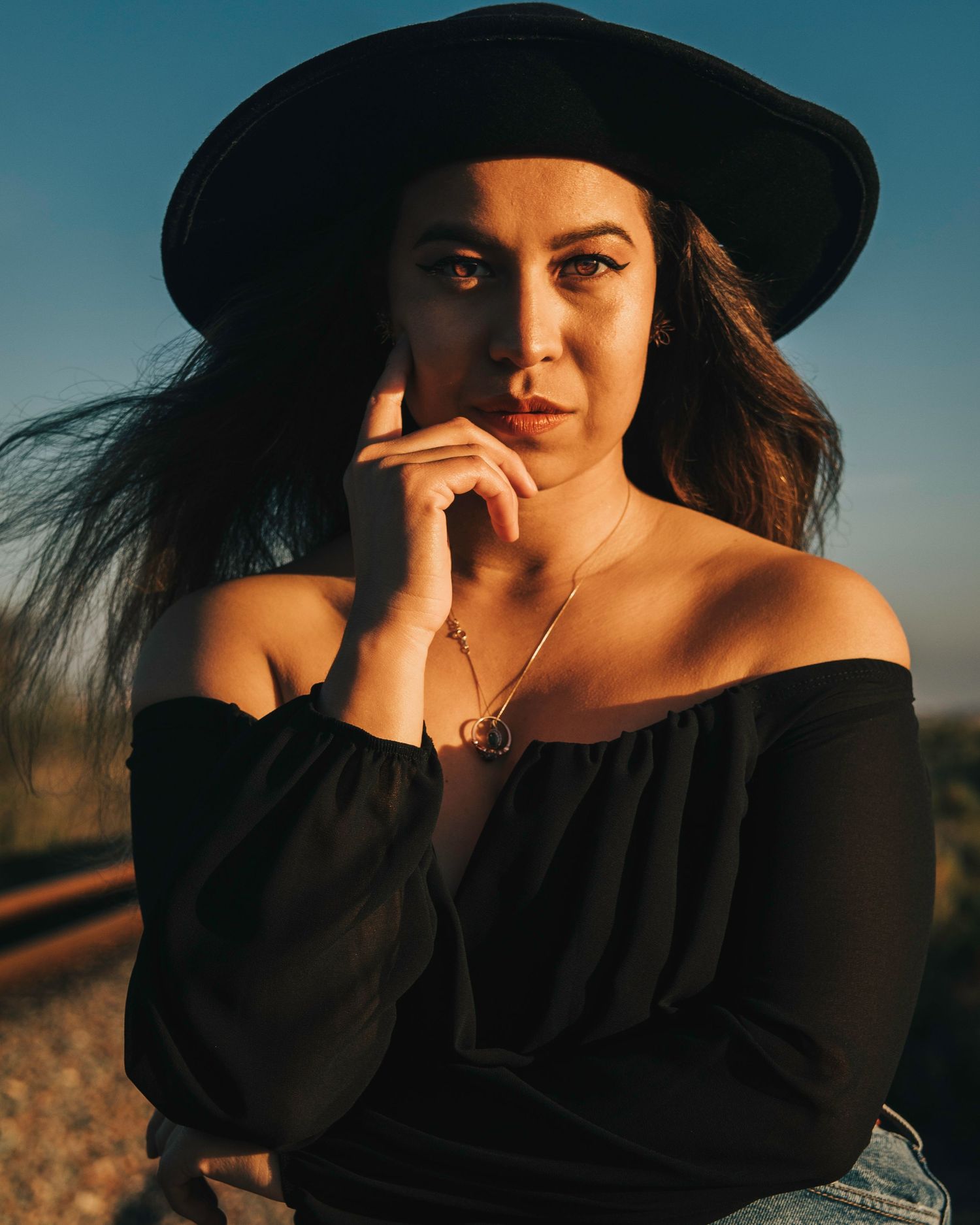 Woman posing in sunlight near train tracks in oceanside, ca