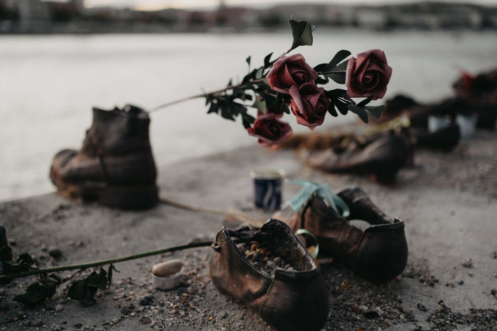Abandoned leather shoes scattered on rough concrete surface.