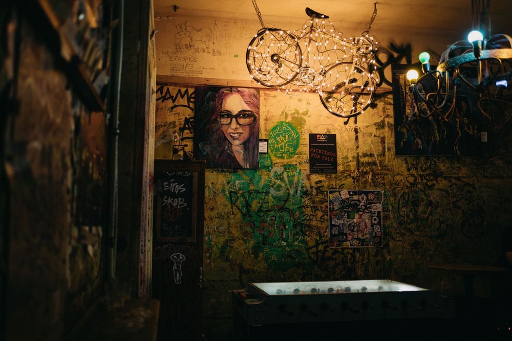 Urban wall with graffiti art illuminated by warm streetlights at night.