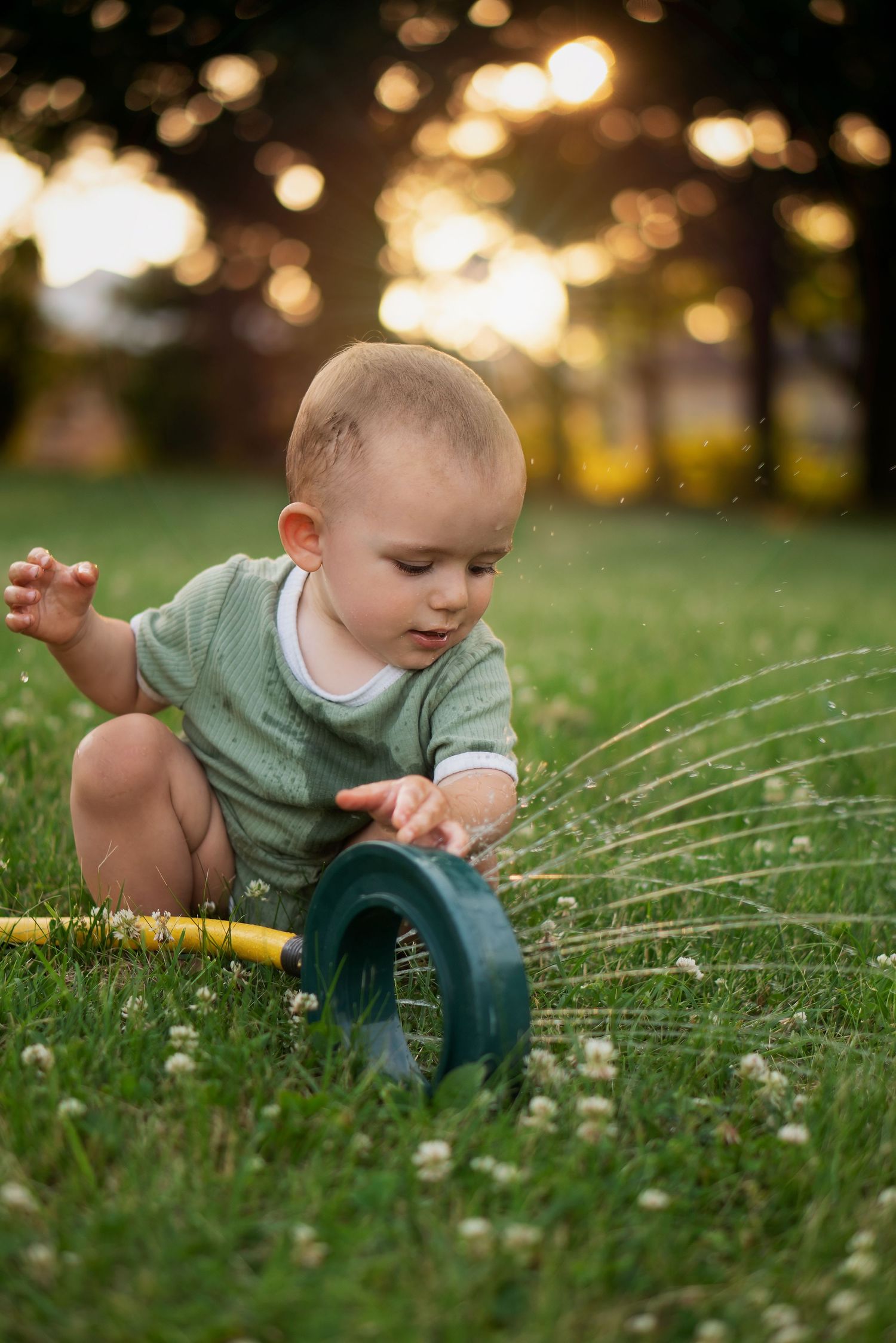 toddler plays with sprinkler