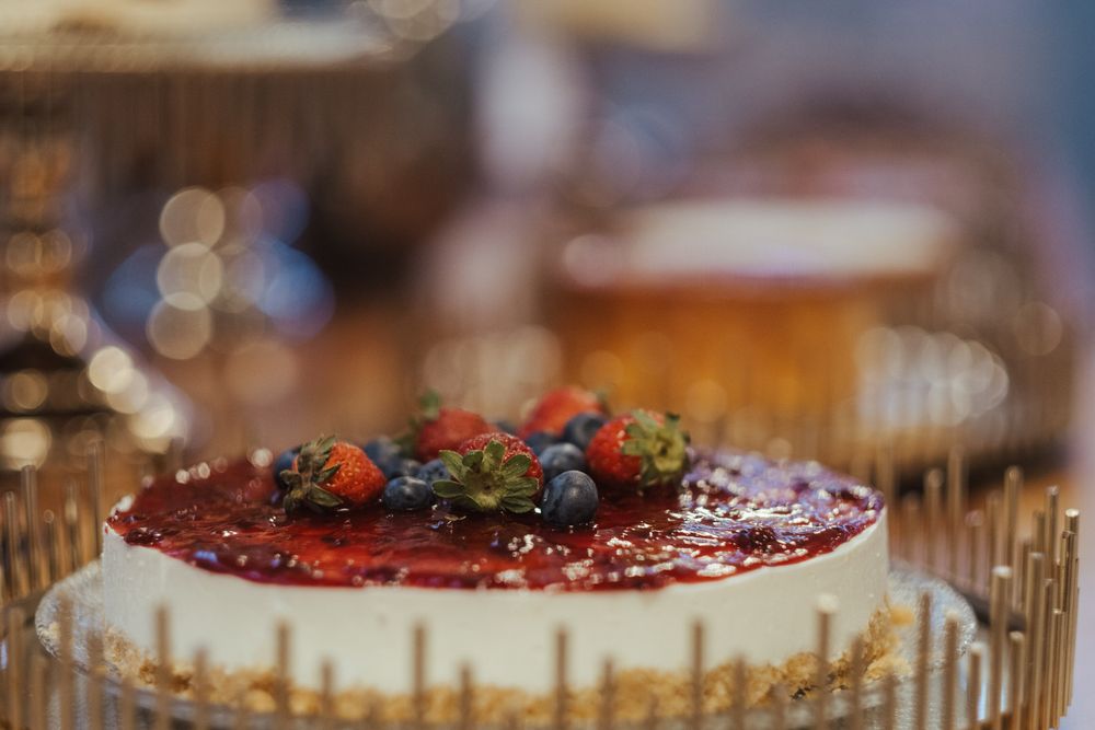 Frutos vermelhos e outras frutas coloridas adornam um prato de sobremesas lindamente decorado numa receção de casamento.