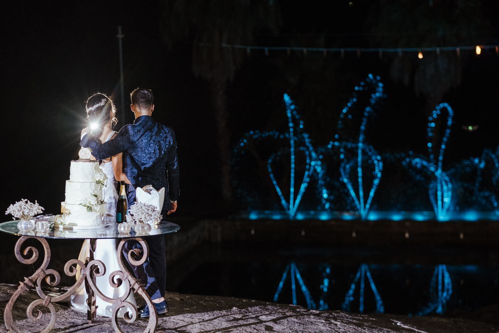 Receção de casamento ao ar livre com luzes azuis na fonte, criando uma atmosfera mágica.