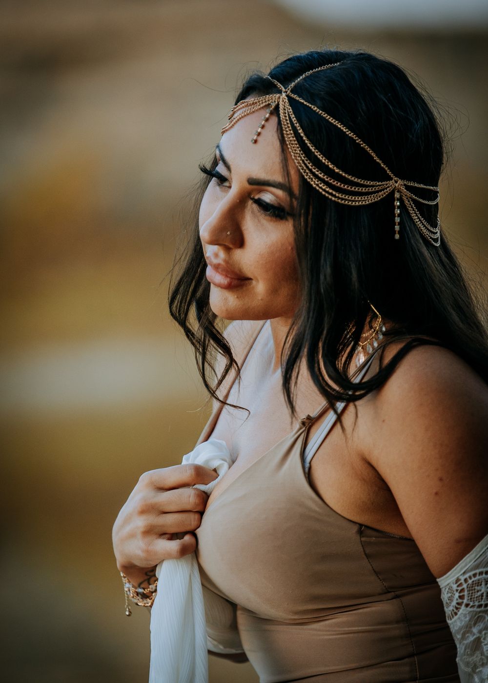 Golden hour portrait wearing delicate chain headpiece and neutral toned outfit.