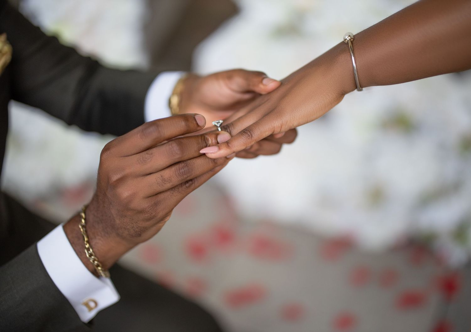 Close-up of hands during wedding proposal with ring exchange.