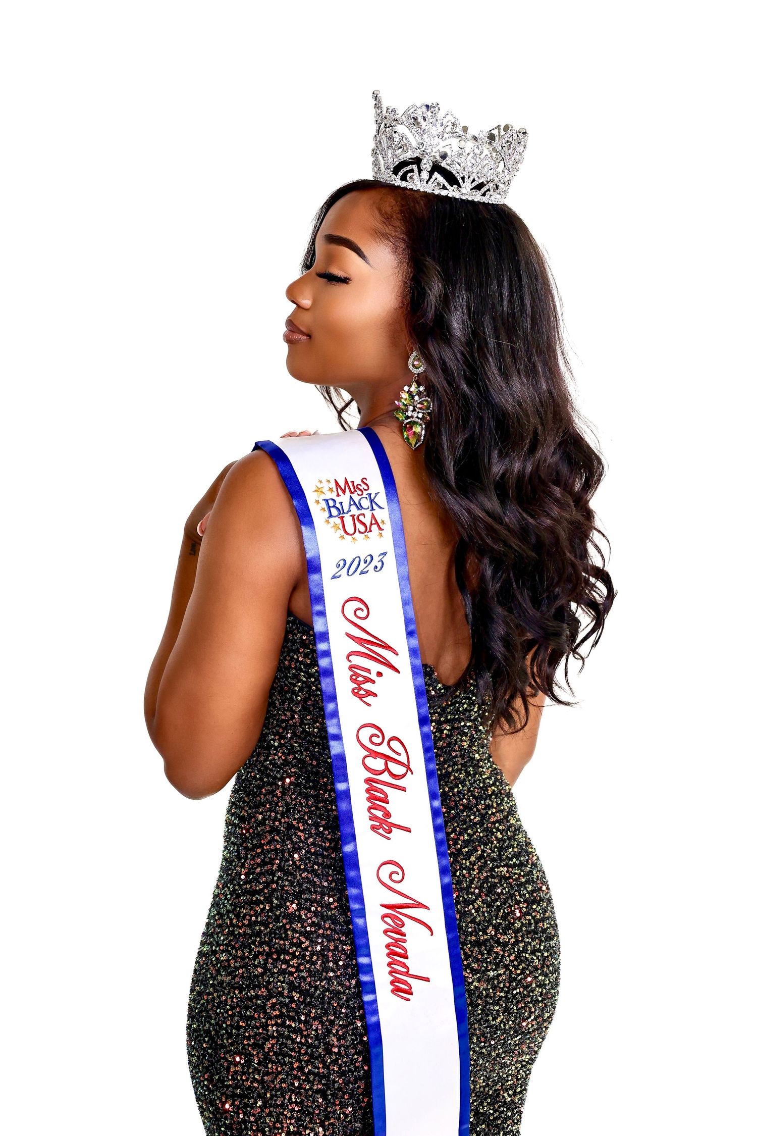 Pageant winner in sparkling gown and crown with blue sash.