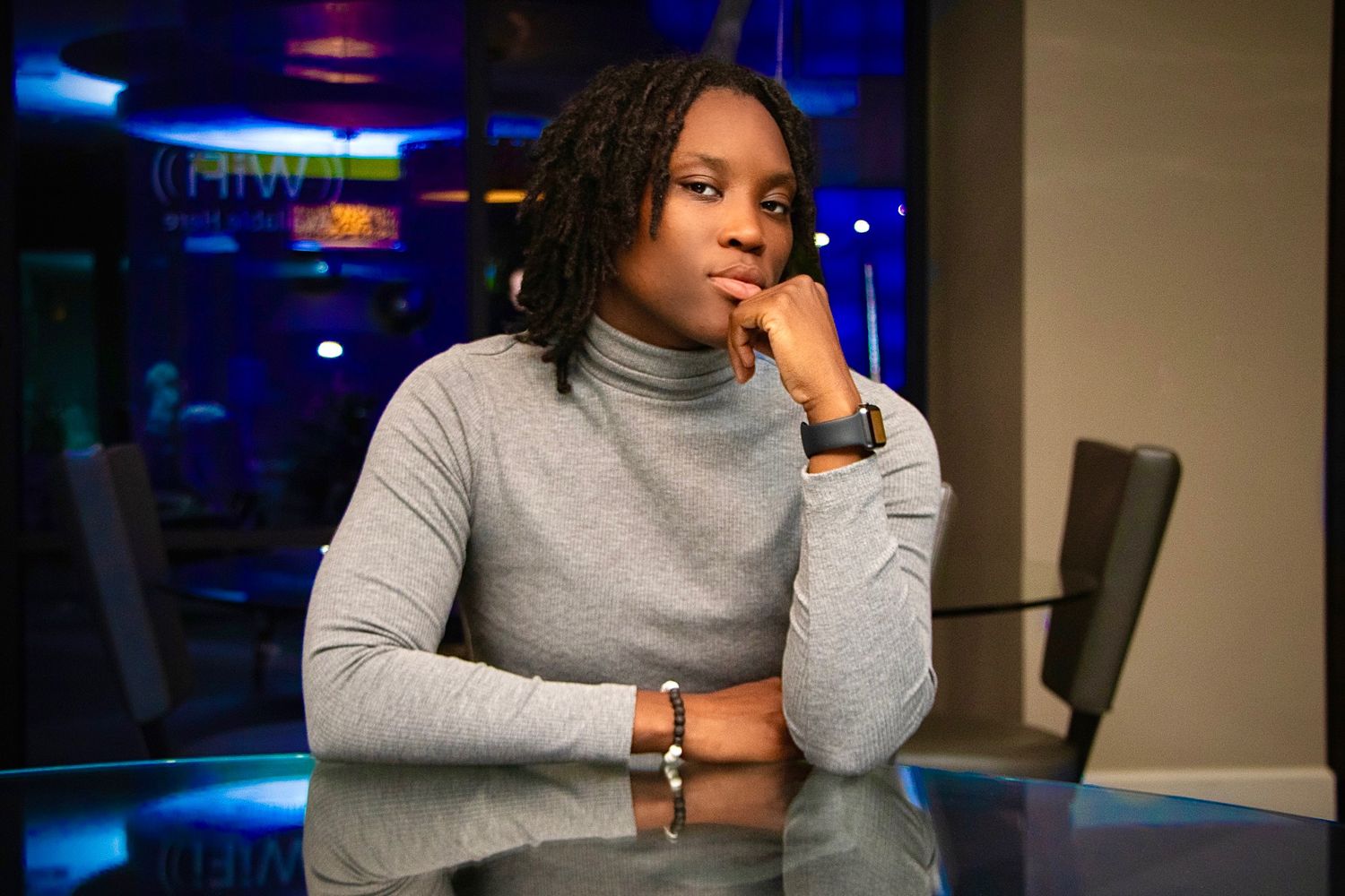 A pensive moment captured in an office setting with ambient blue lighting.