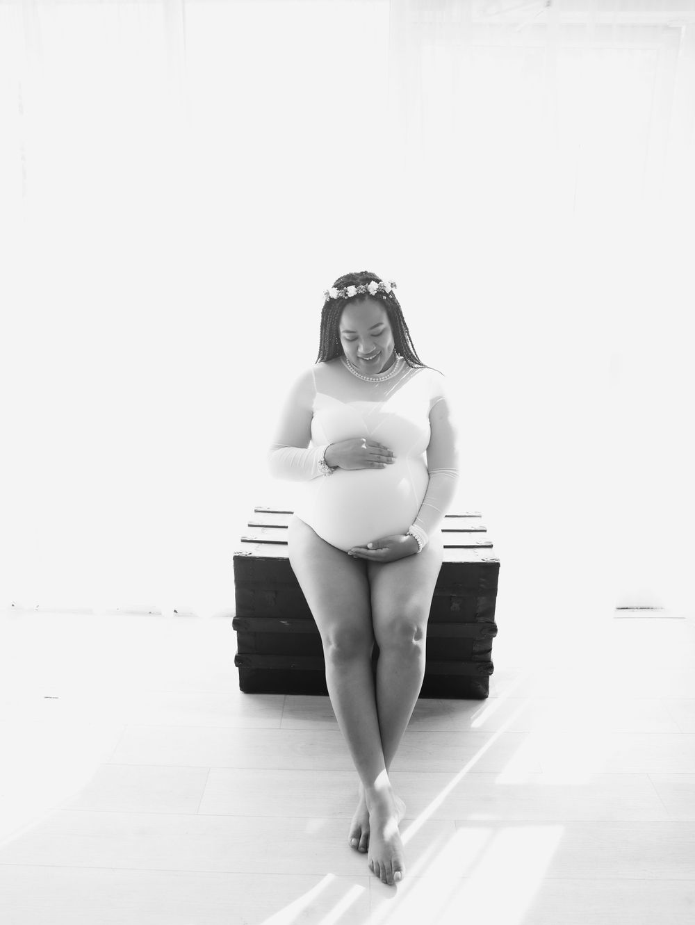 Black and white maternity portrait of expectant mother wearing flower crown.