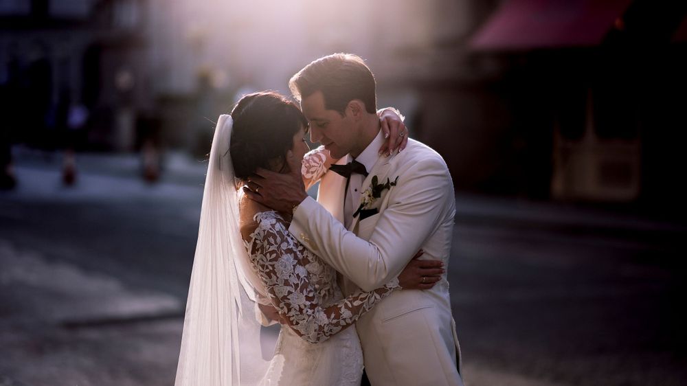 Intimate moment between newlyweds during golden hour on a city street.