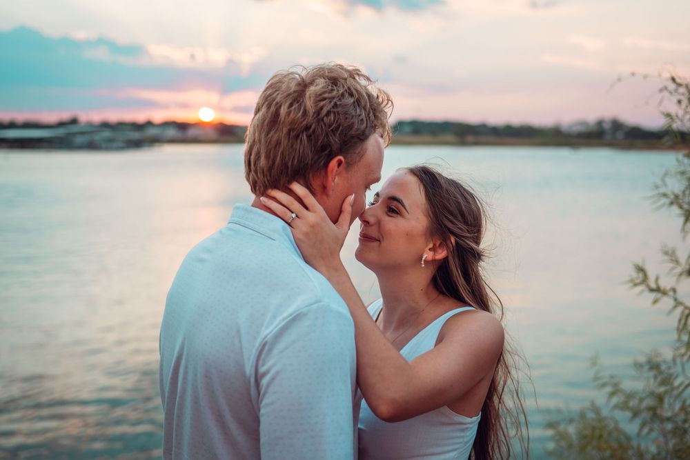 Romantic sunset photoshoot by the lake with soft pastel sky.