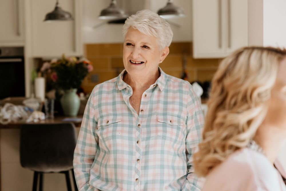 Candid moment captured in a bright kitchen during wedding day preparations.