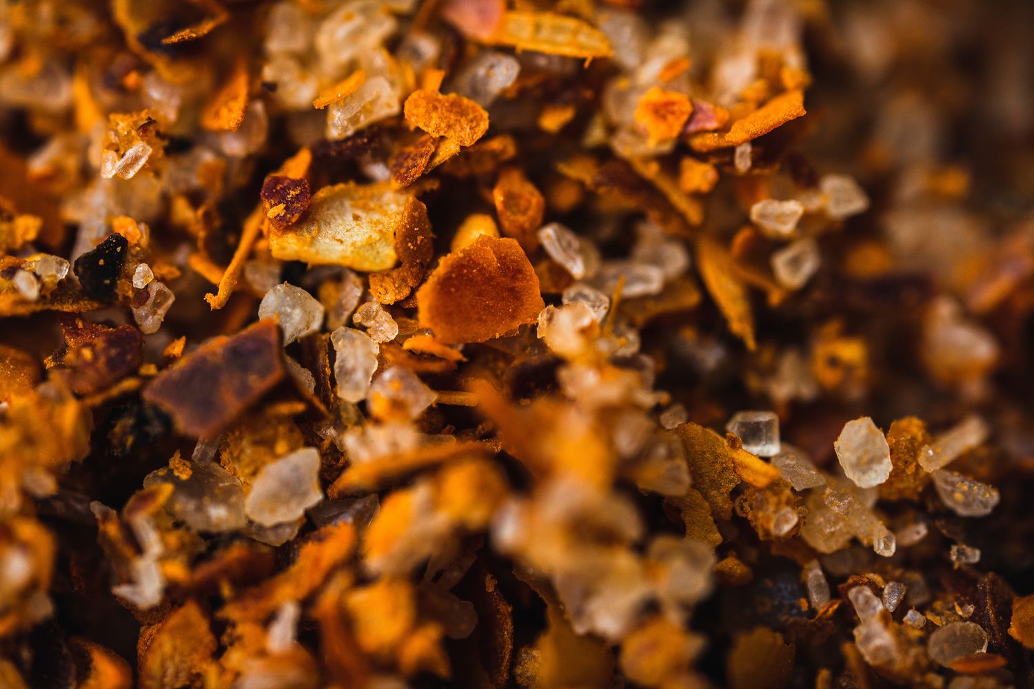 Macro photography of orange crystalline mineral structures with detailed patterns.