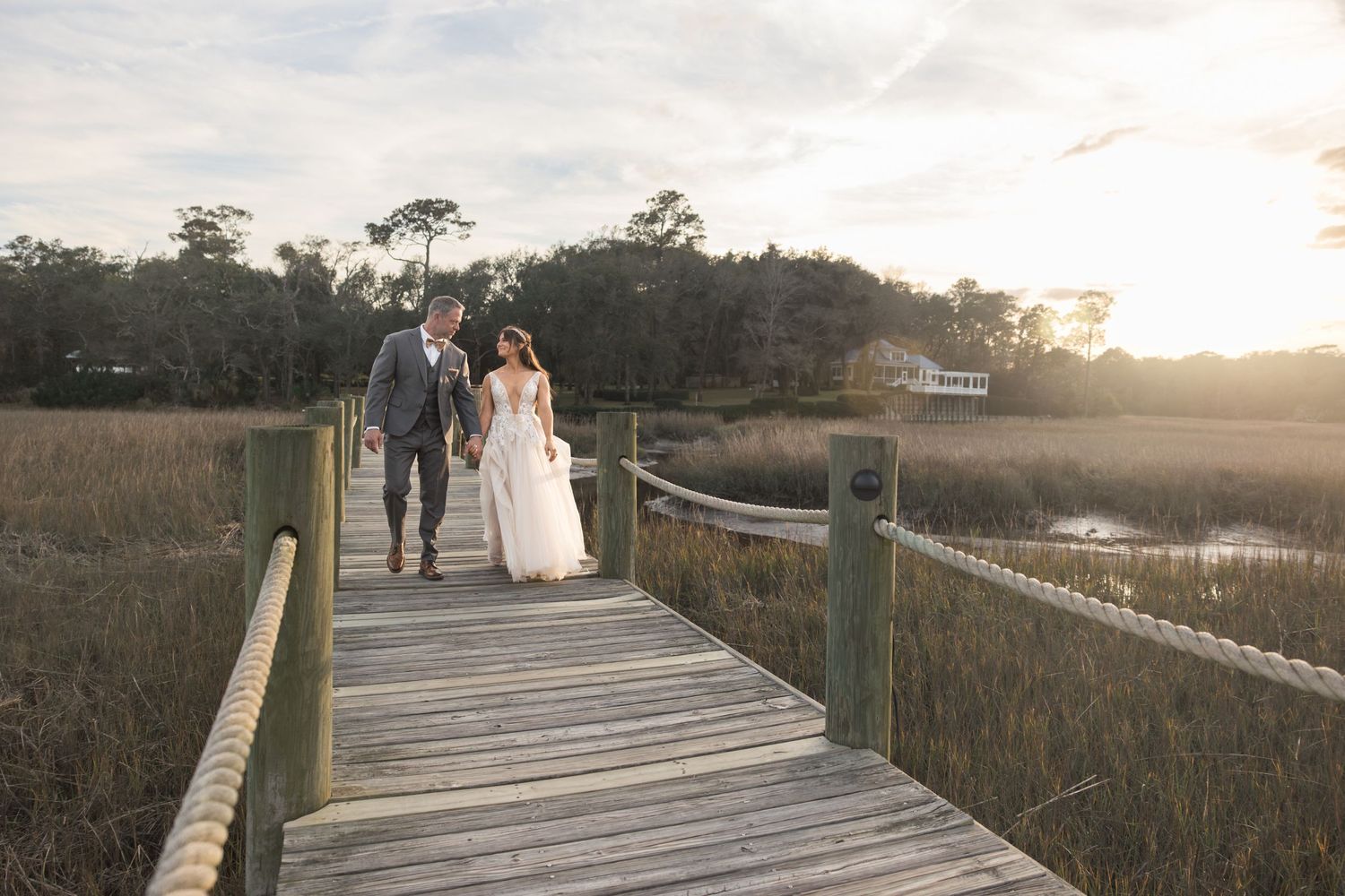 Bride and groom walking on a boardwalk over a marsh in Yulee Florida