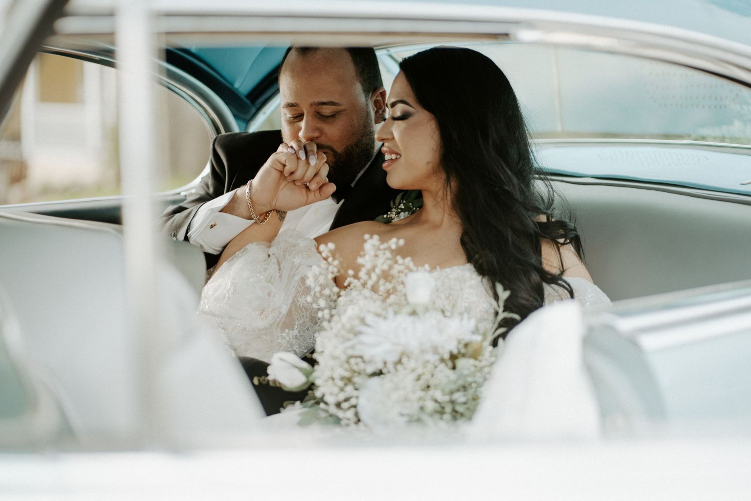 Wedding couple in blue vintage car. Man kissing womans hand at the Lakeside Inn in Mount Dora FL