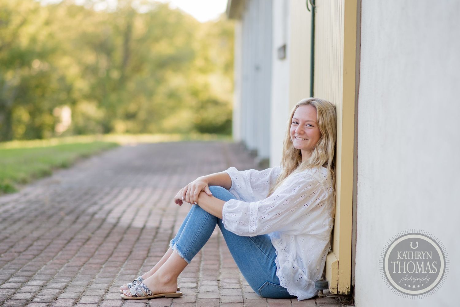 Casual outdoor portrait against building wall showing relaxed pose in summer attire.