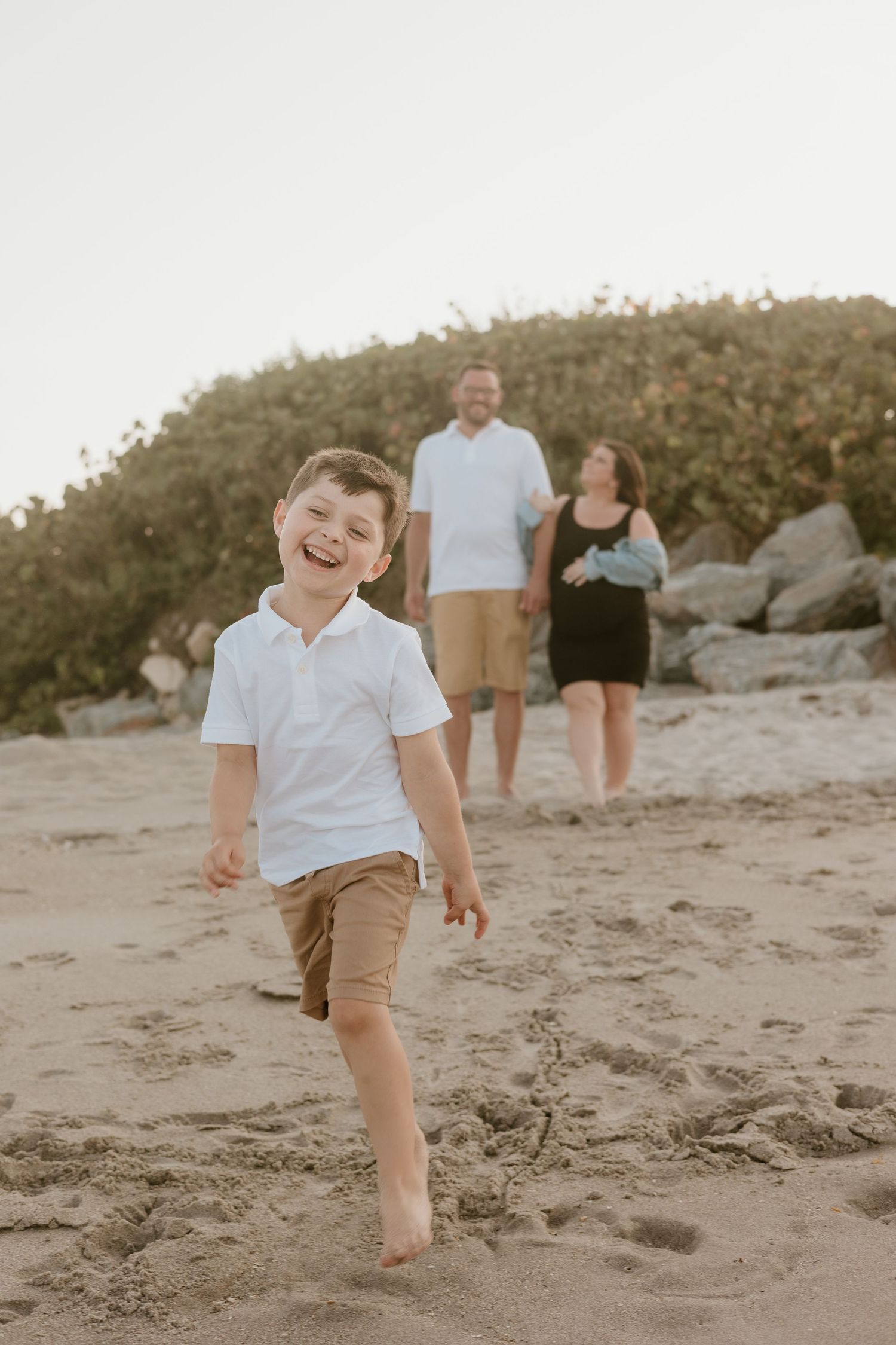 Person jumping and playing in the sand at a beach during golden hour.