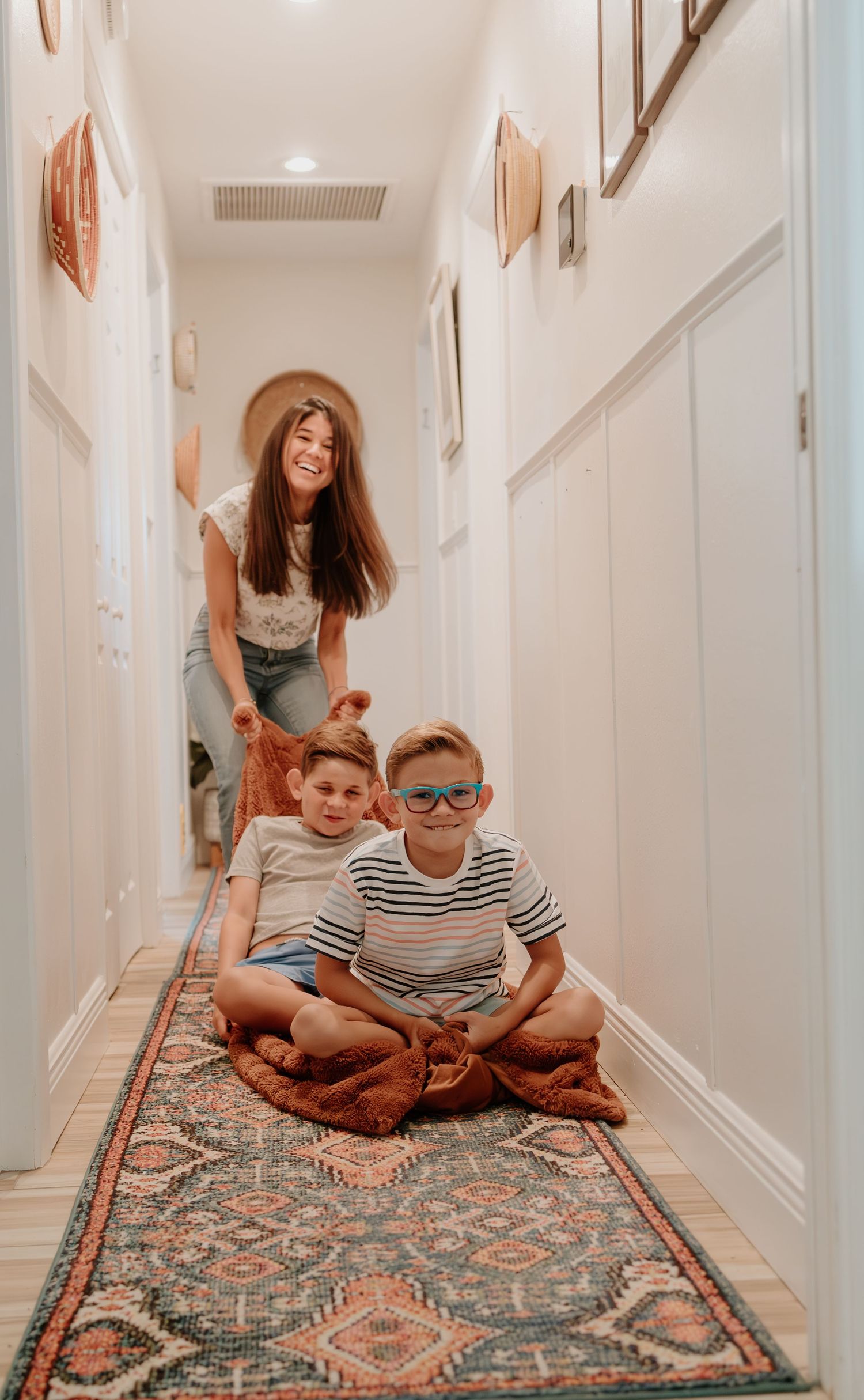 Playful lifestyle photos on a patterned hallway rug showing movement and joy.