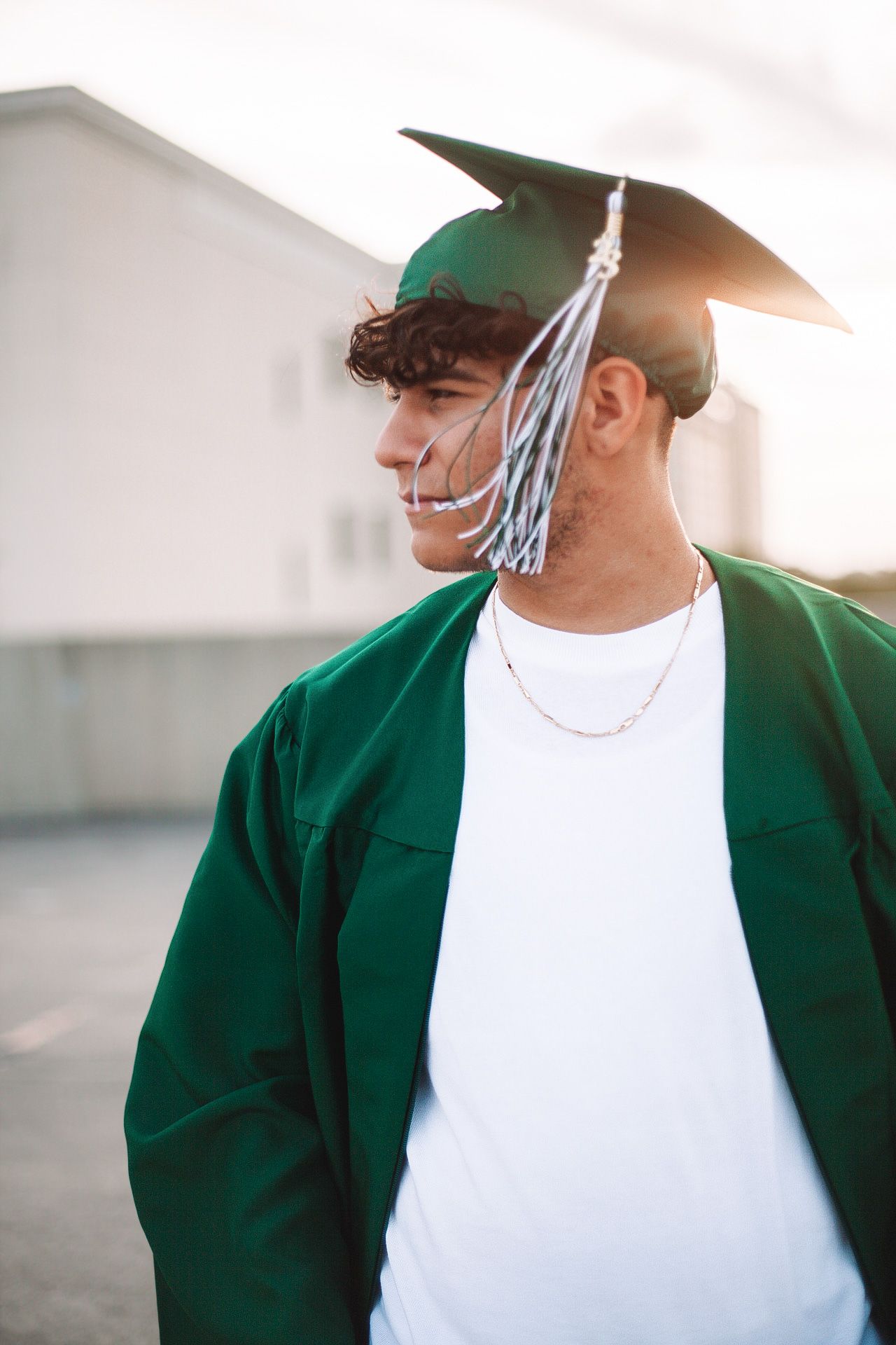 Person wearing green jacket and baseball cap in bright sunlight.