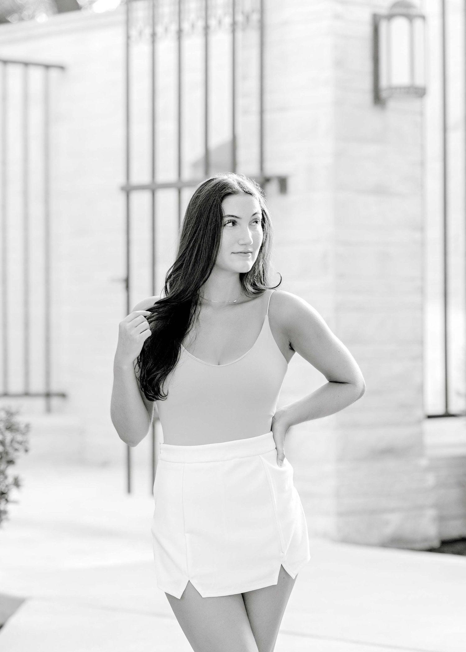 Black and white portrait in soft lighting wearing summer outfit by architectural details.