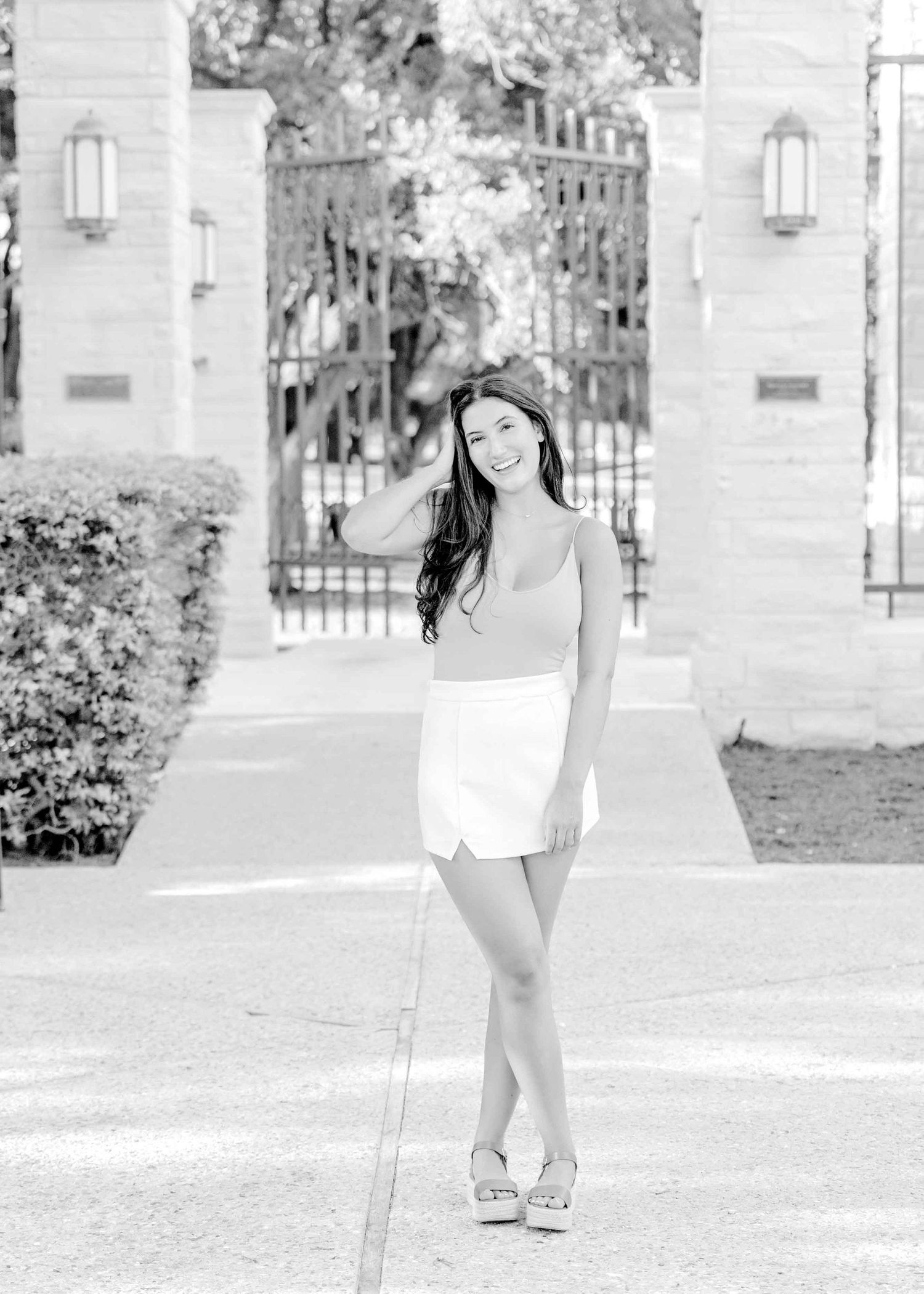 Black and white portrait in front of decorative iron gates and stone columns.