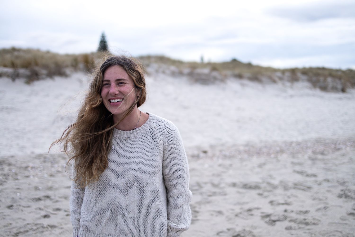 Documentary photographer AnnMarie Dawn poses candidly at her local beach of Omaha, New Zealand.