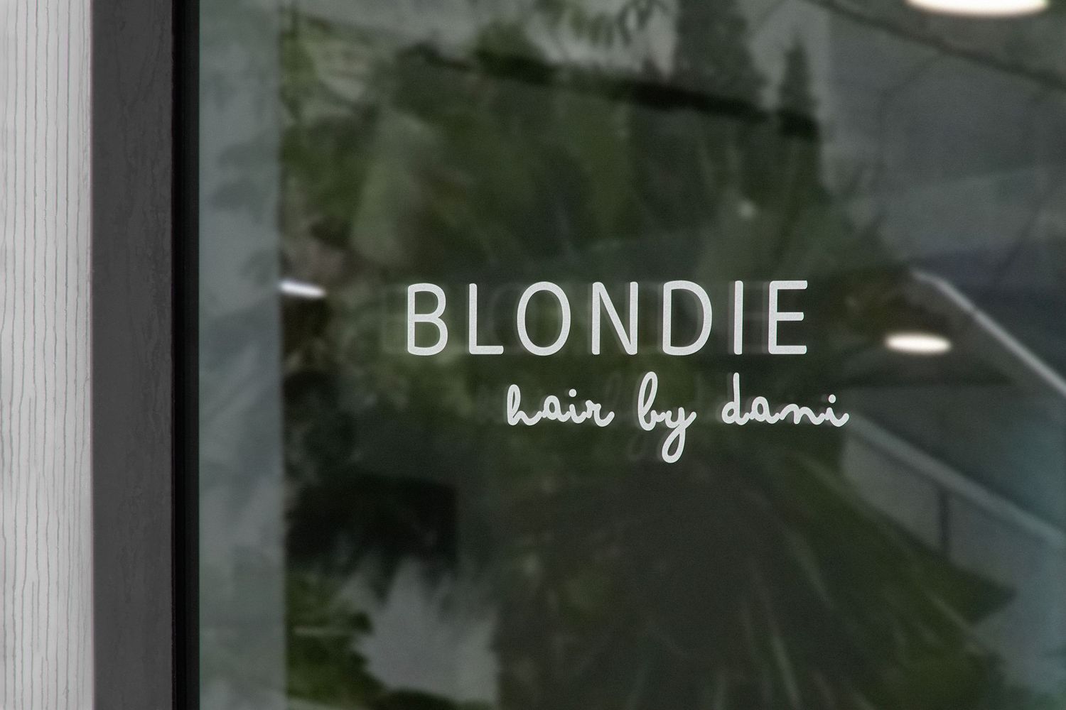 Dark storefront exterior with illuminated Blondie hair salon signage.