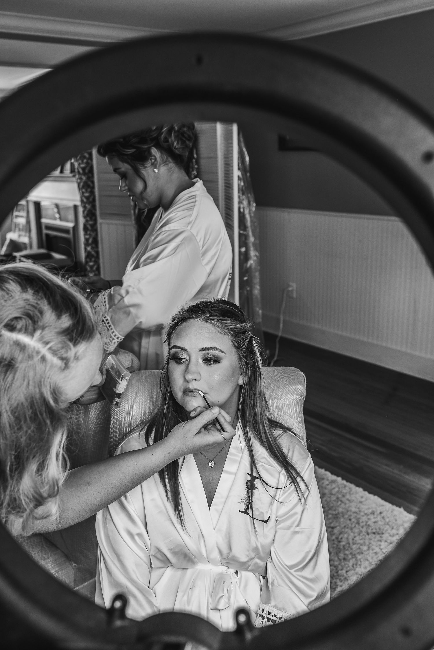 Black and white getting ready photos showing wedding day makeup preparations.