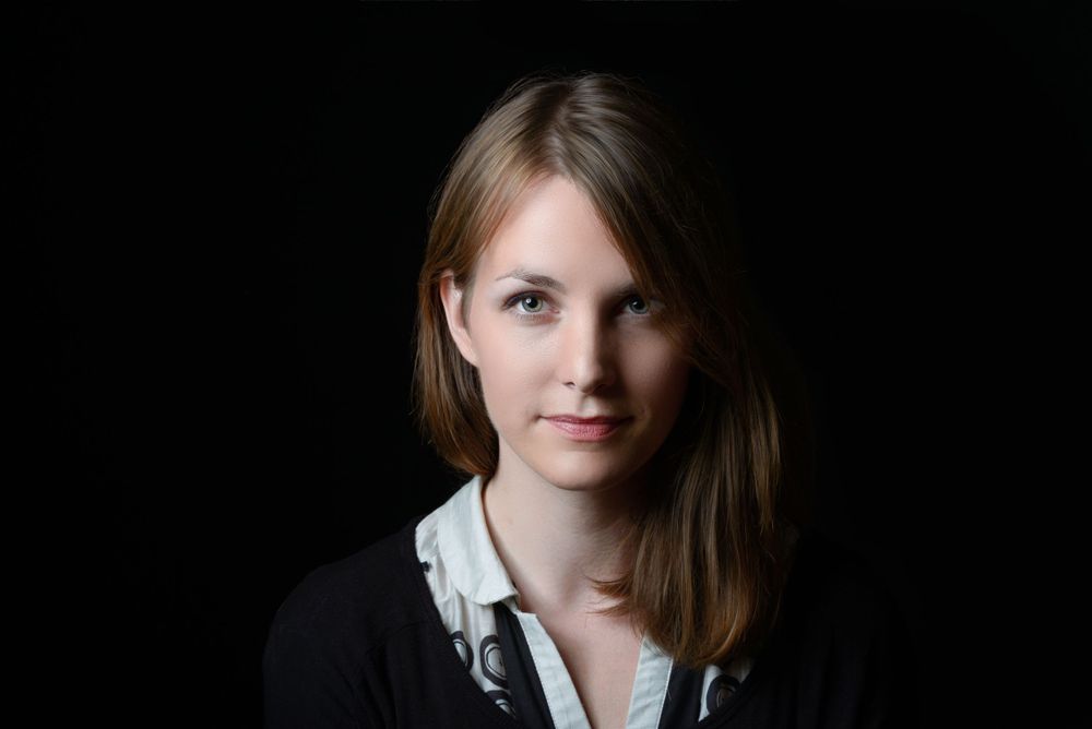 Dramatic portrait of a woman on a black background facing directly to the camera
