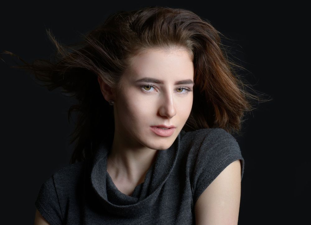 Portrait of a woman with hair in the wind on a black background