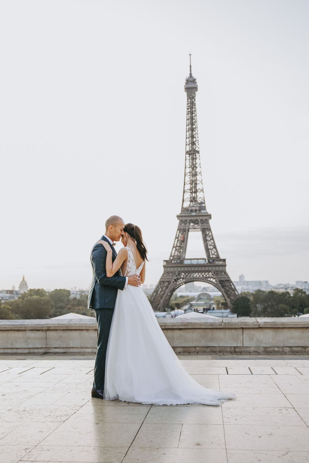 Wedding couple sharing a romantic moment with the iconic Eiffel Tower as their backdrop in Paris.