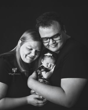 Black & white family photo with newborn baby girl; mom & dad in black holding newborn baby Lexington, SC photographer