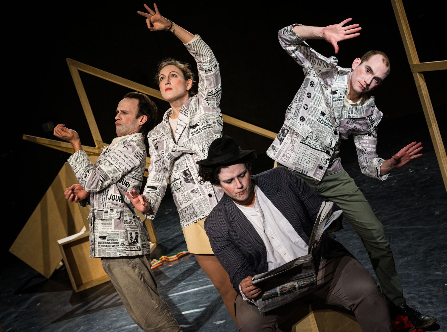 Performers in matching outfits striking dynamic poses during a theatrical performance.