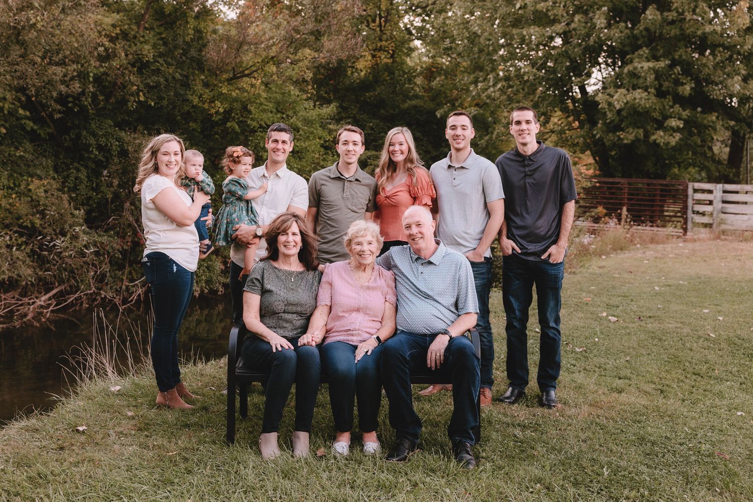 Extended family group photo with multiple generations posing together outdoors.