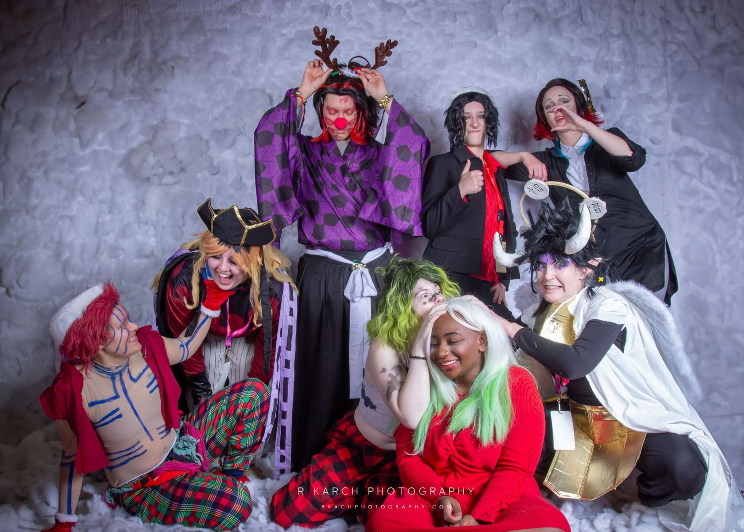 Group of cosplayers posing together in festive holiday-themed costumes.