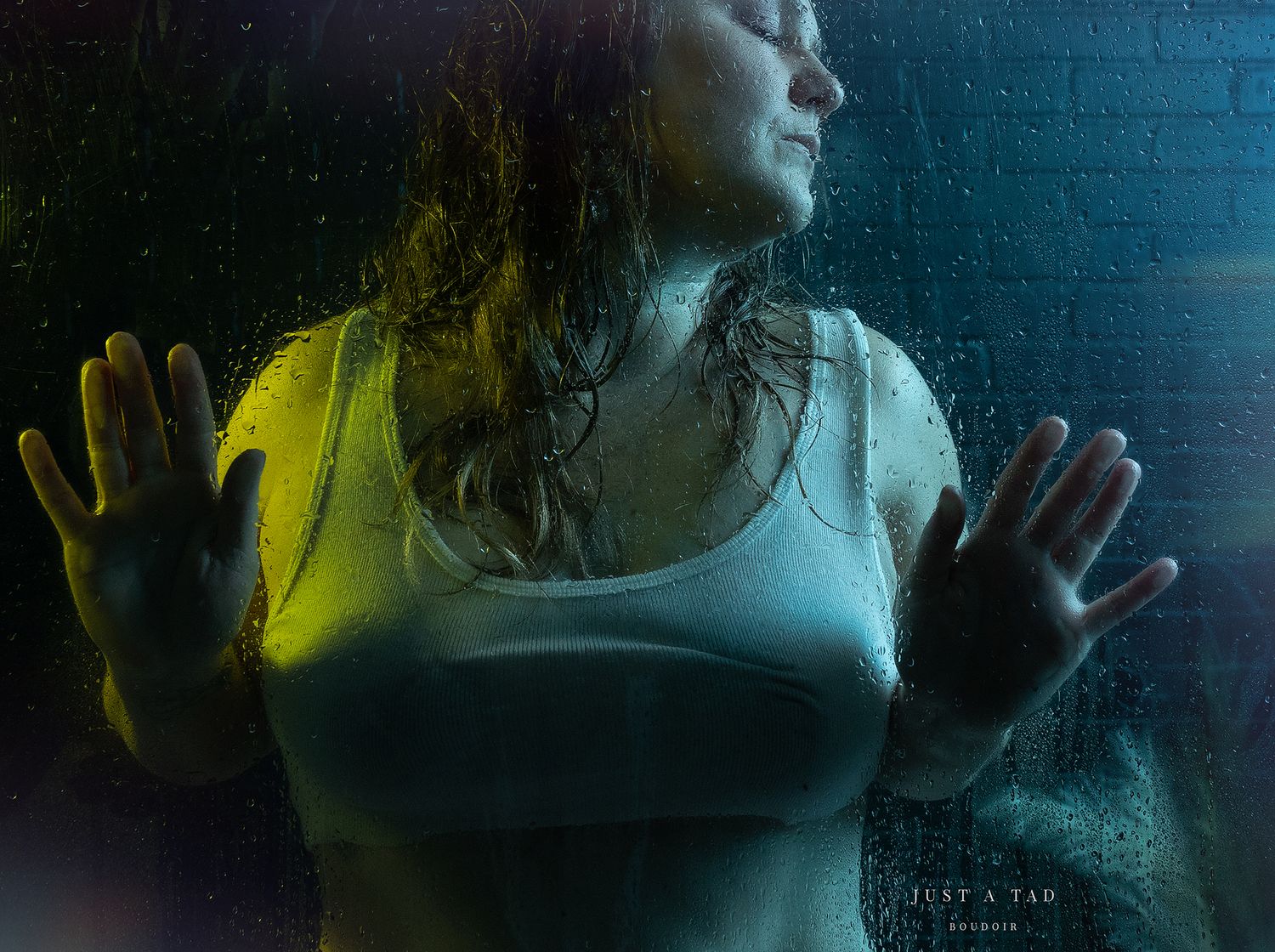 Steamy shower scene with blue lights of lady in a white crop-top tank top. Greenville, SC boudoir photographer Easley SC boudoir