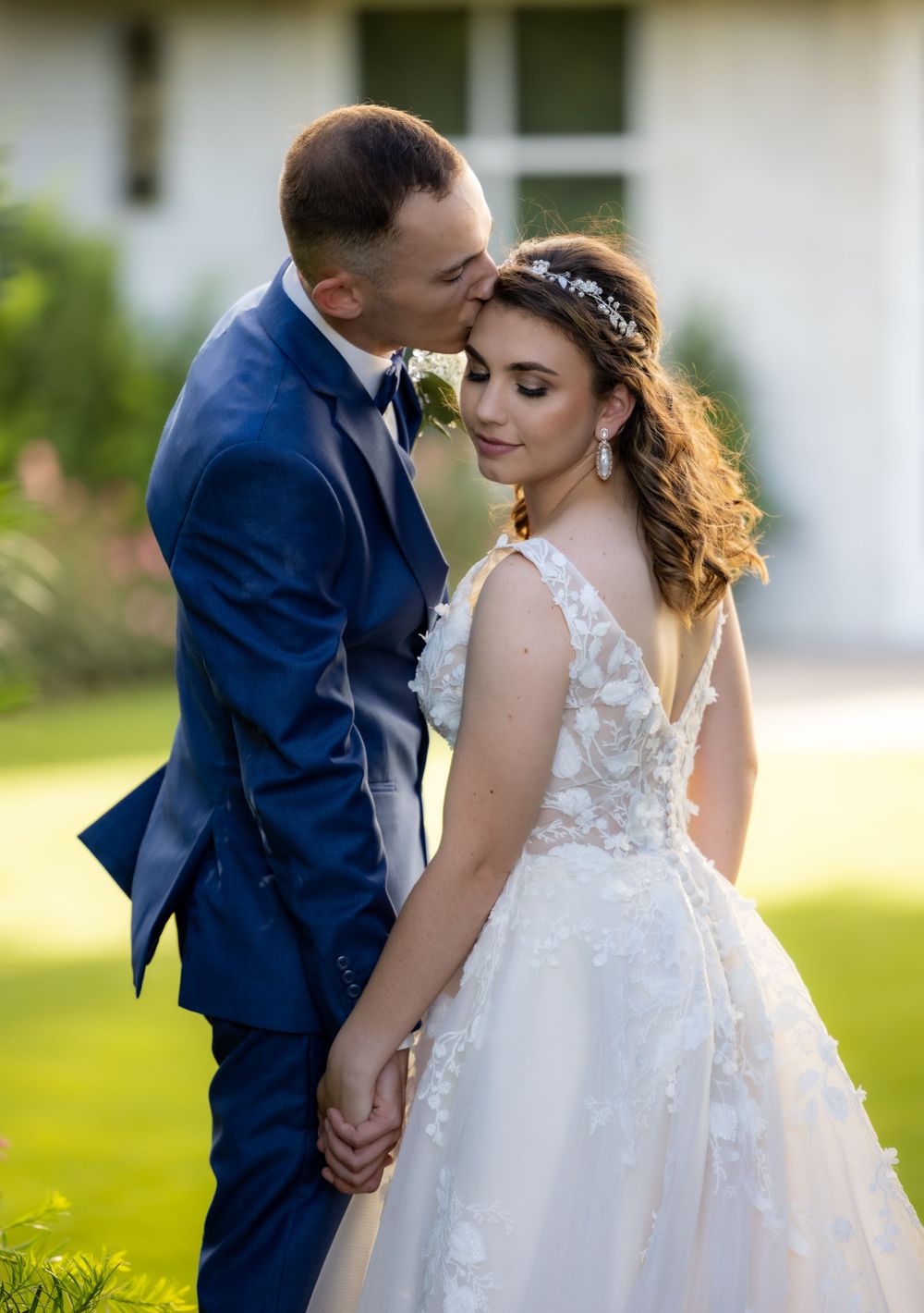 Groom kisses the bride at their wedding outside in the court yard photoshoot
