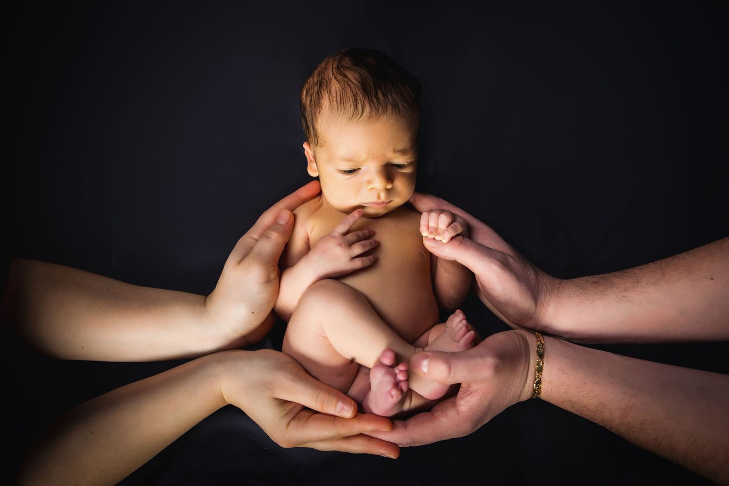 baby boy in parent's hands