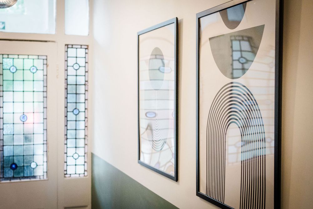 Interior propreté image showing framed prints hung beside front door with pretty stained glass