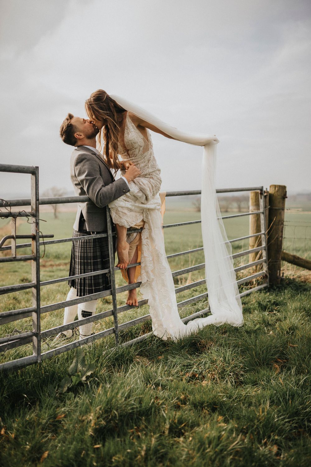 Paul Mavor Aberdeen Wedding Photographer at Bara Barn bride and groom on fence kissing