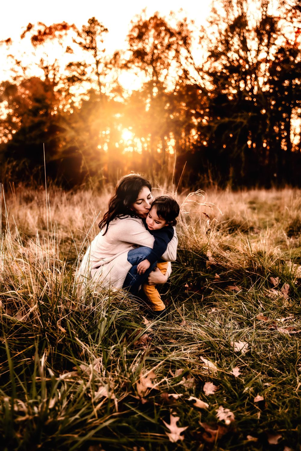 A tender moment shared between parent and child in a sunlit field.