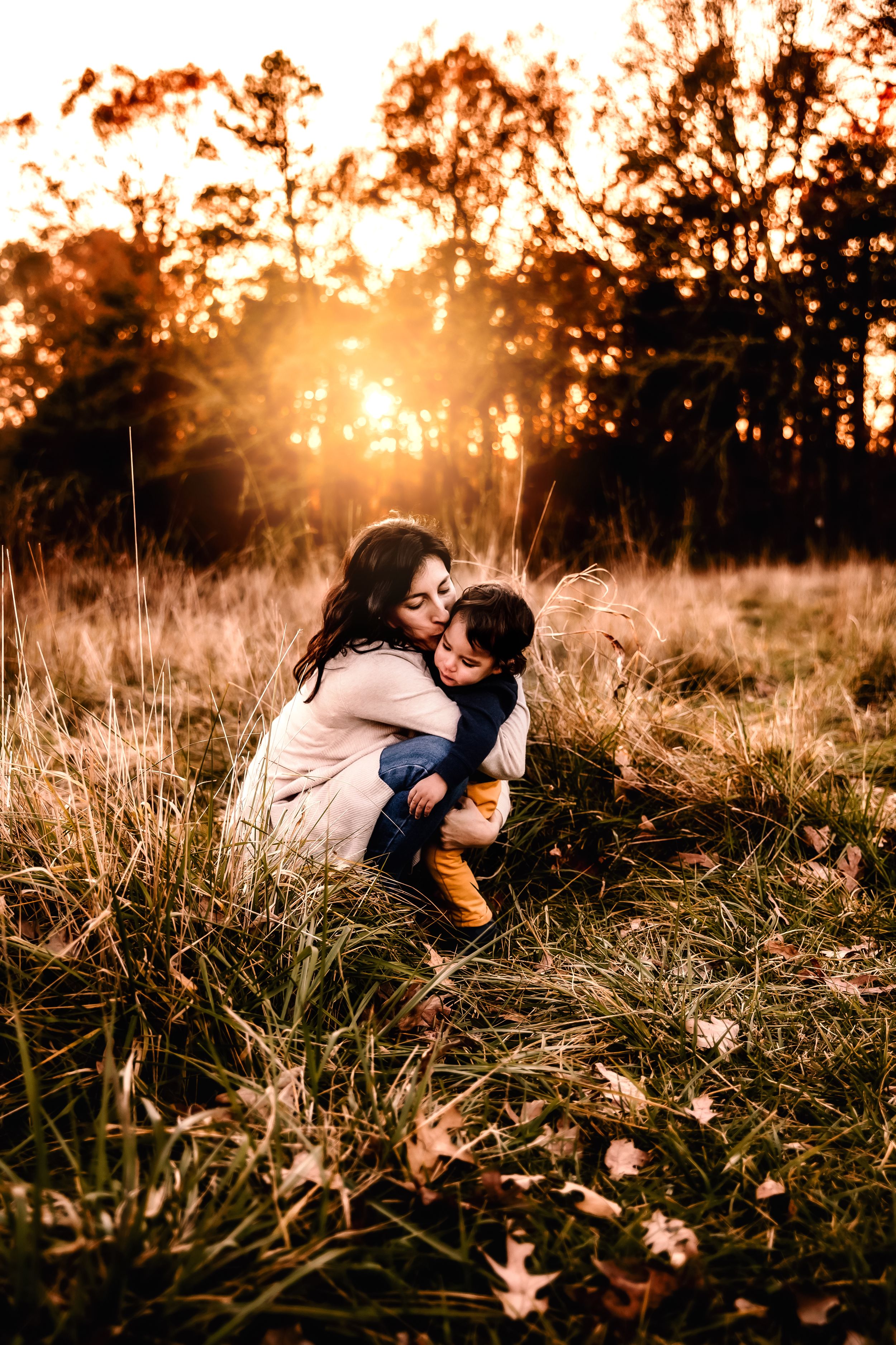 A tender moment shared between parent and child in a sunlit field.