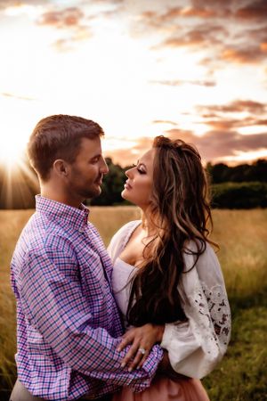 A romantic sunset photoshoot in a golden wheat field during magic hour.