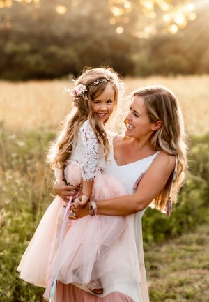 A heartwarming mother-daughter moment in matching pink tulle skirts at sunset.